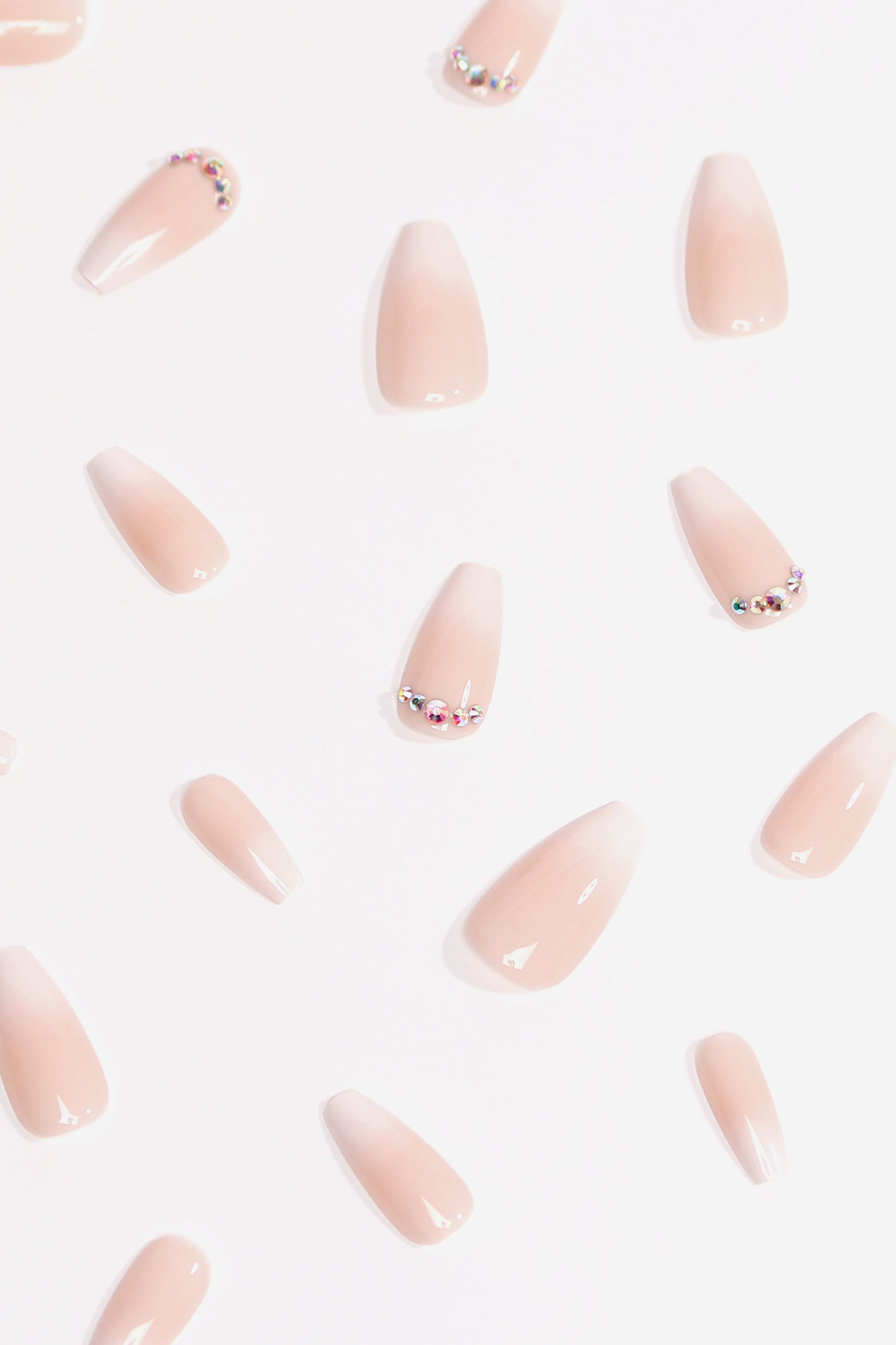 Set of nude pink press-on nails with small gems and French-style tips