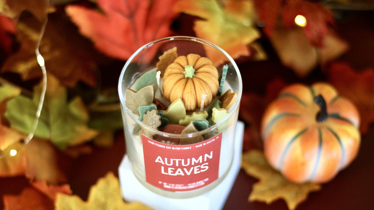 Autumn leaves scented candle in clear glass jar with pumpkin and leaf wax topper