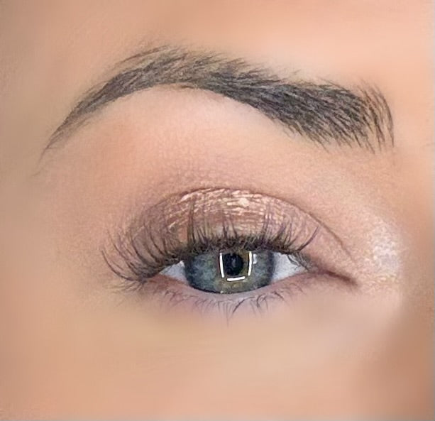 Curled dark eyelash extensions on blue-green eye, full lash line