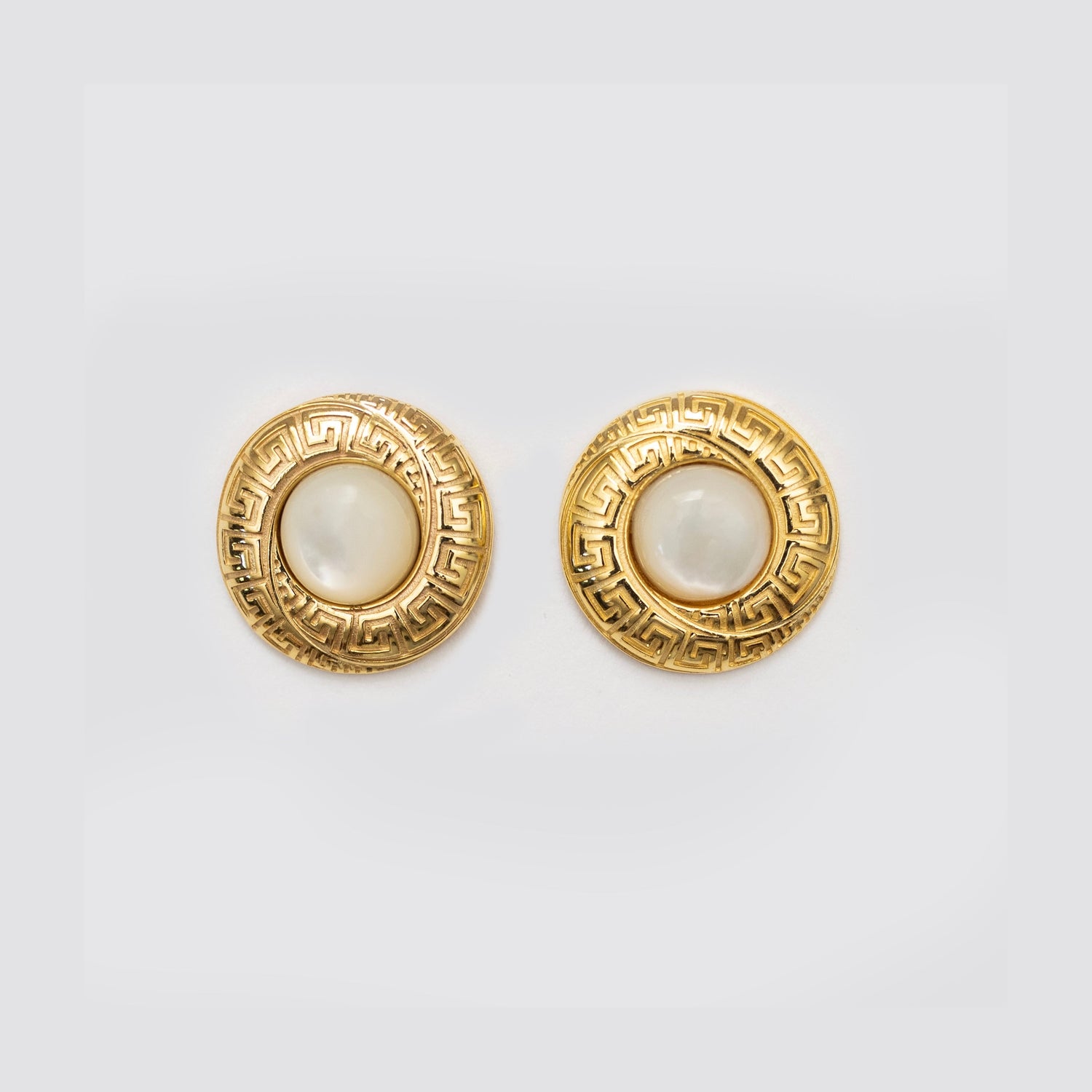 Gold circular earrings with white pearl centers and ornate Greek-key border