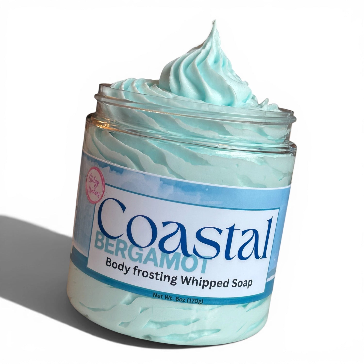 Teal whipped body frosting soap in clear jar with open swirl top