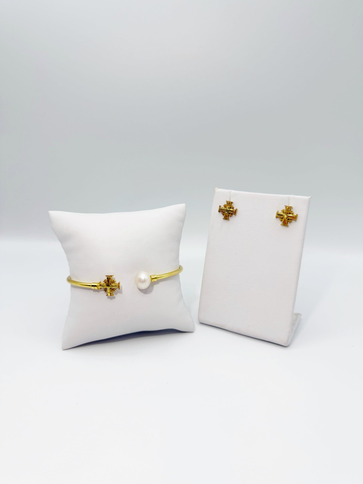 Gold cuff bracelet with pearl plus two cross stud earrings on white box