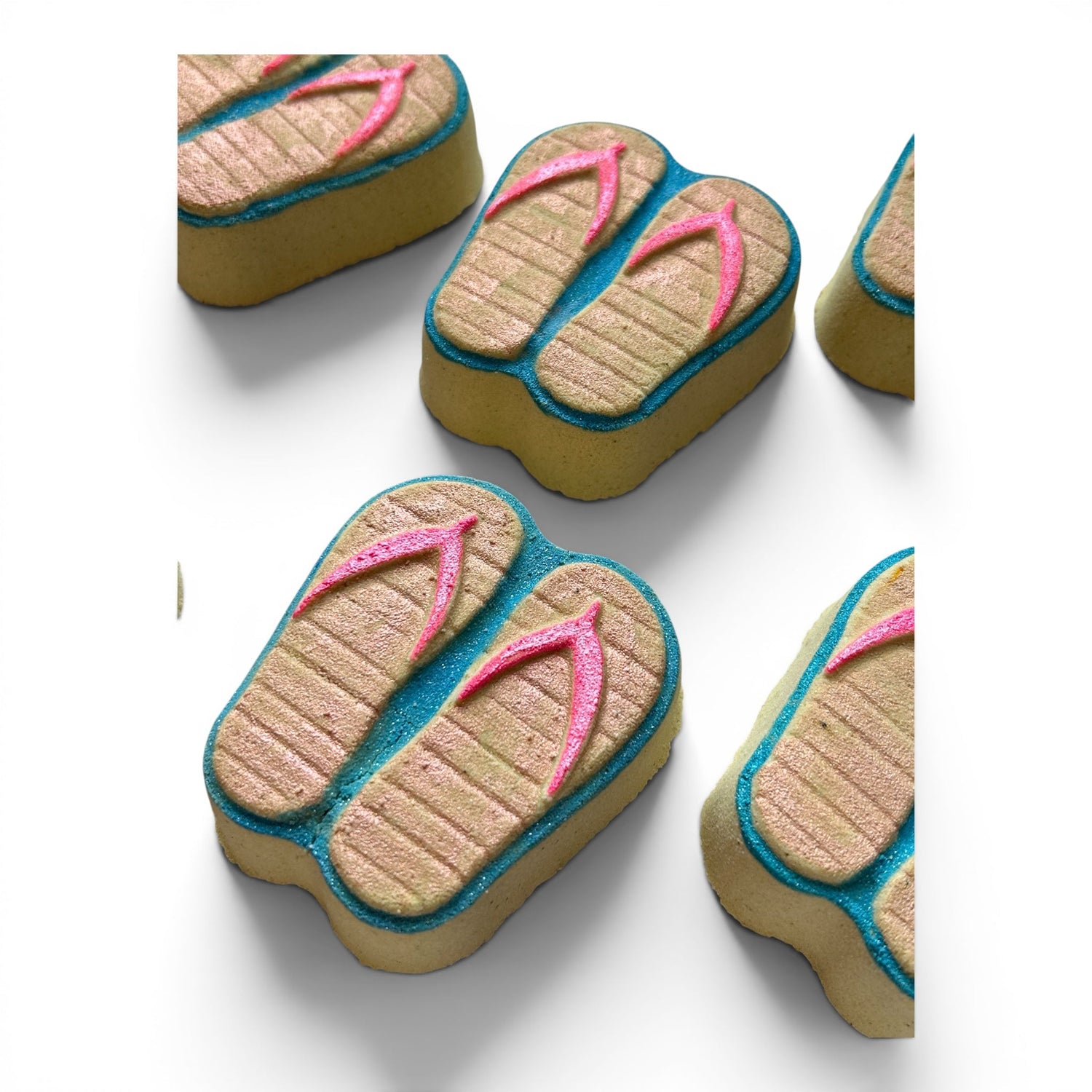 Flip-flop bath bombs, multiple angles; tan soles, pink thongs, turquoise trim