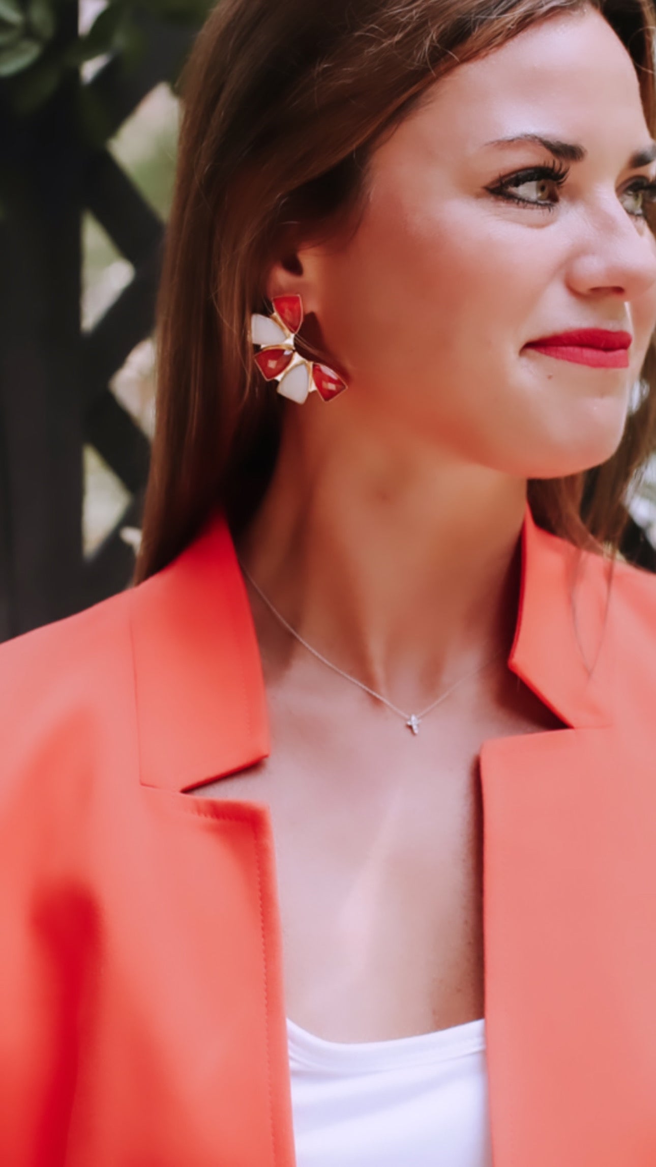 Orange and white mosaic flower earrings worn by a model