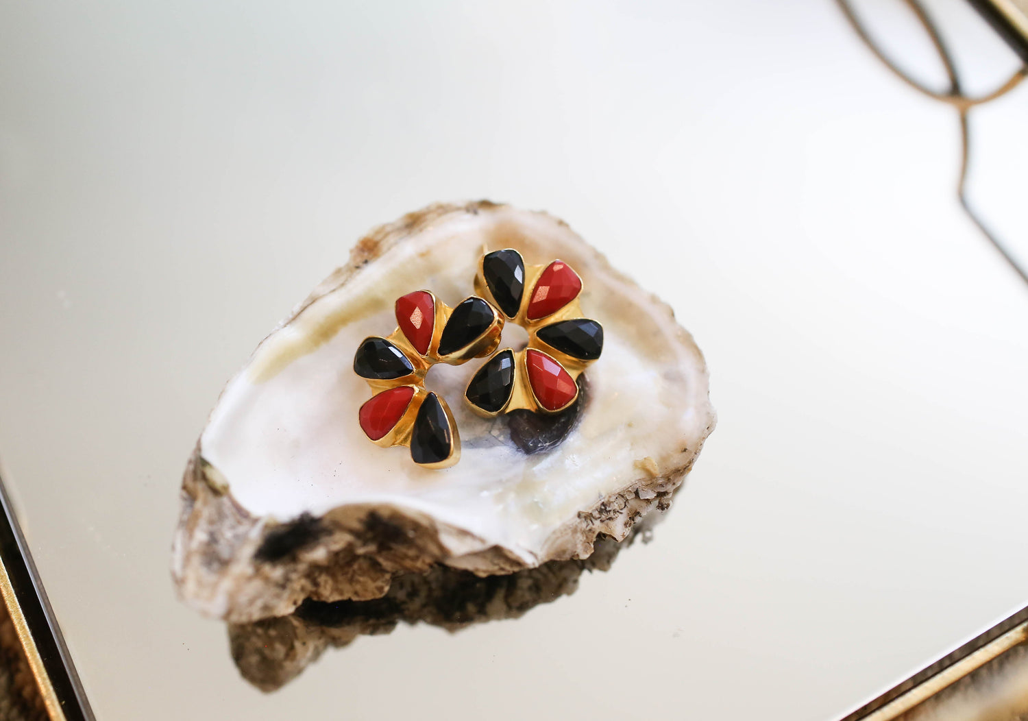 Gold-plated flower stud earrings with black and red faceted quartz stones