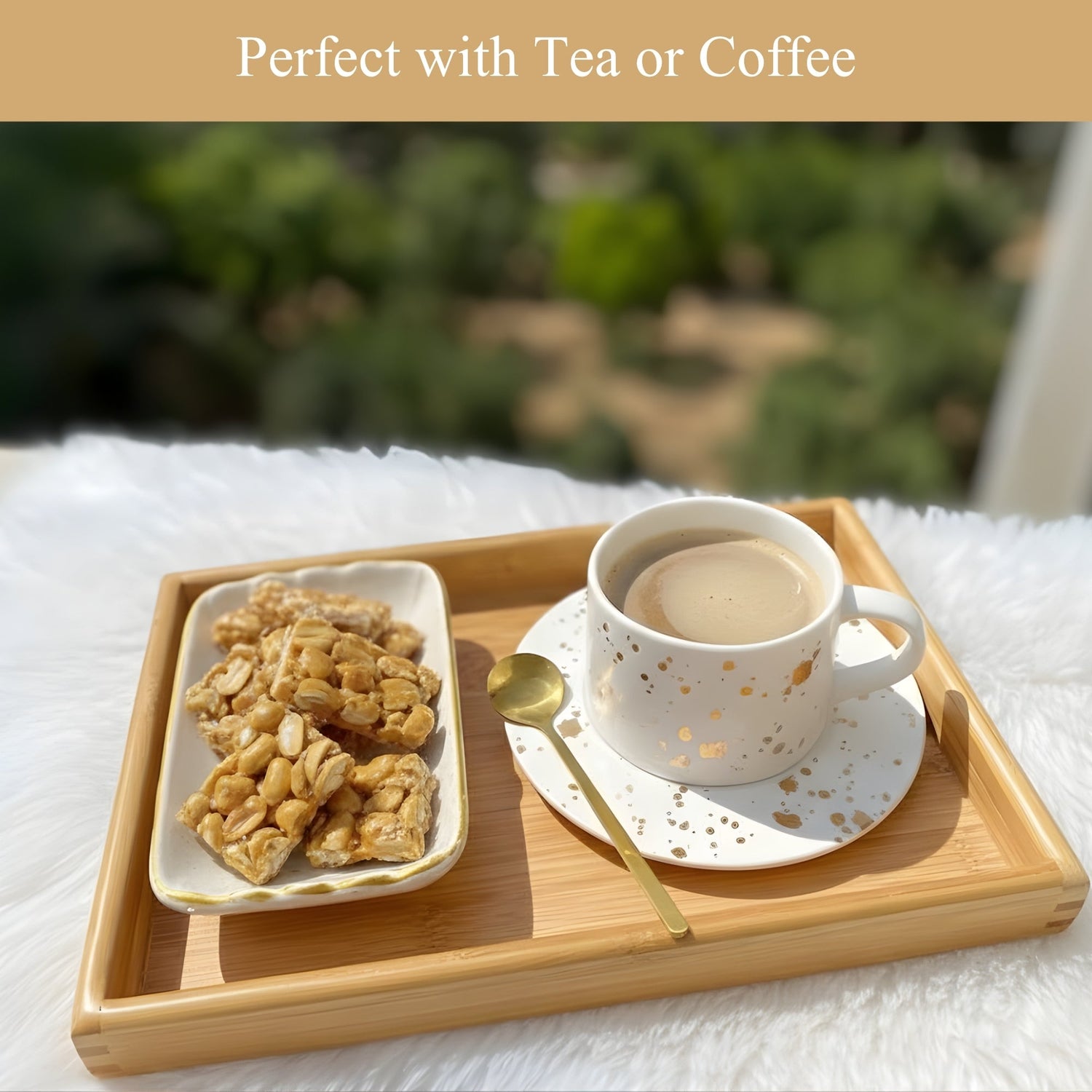 Cashew brittle pieces in a wooden tray with a cup of coffee