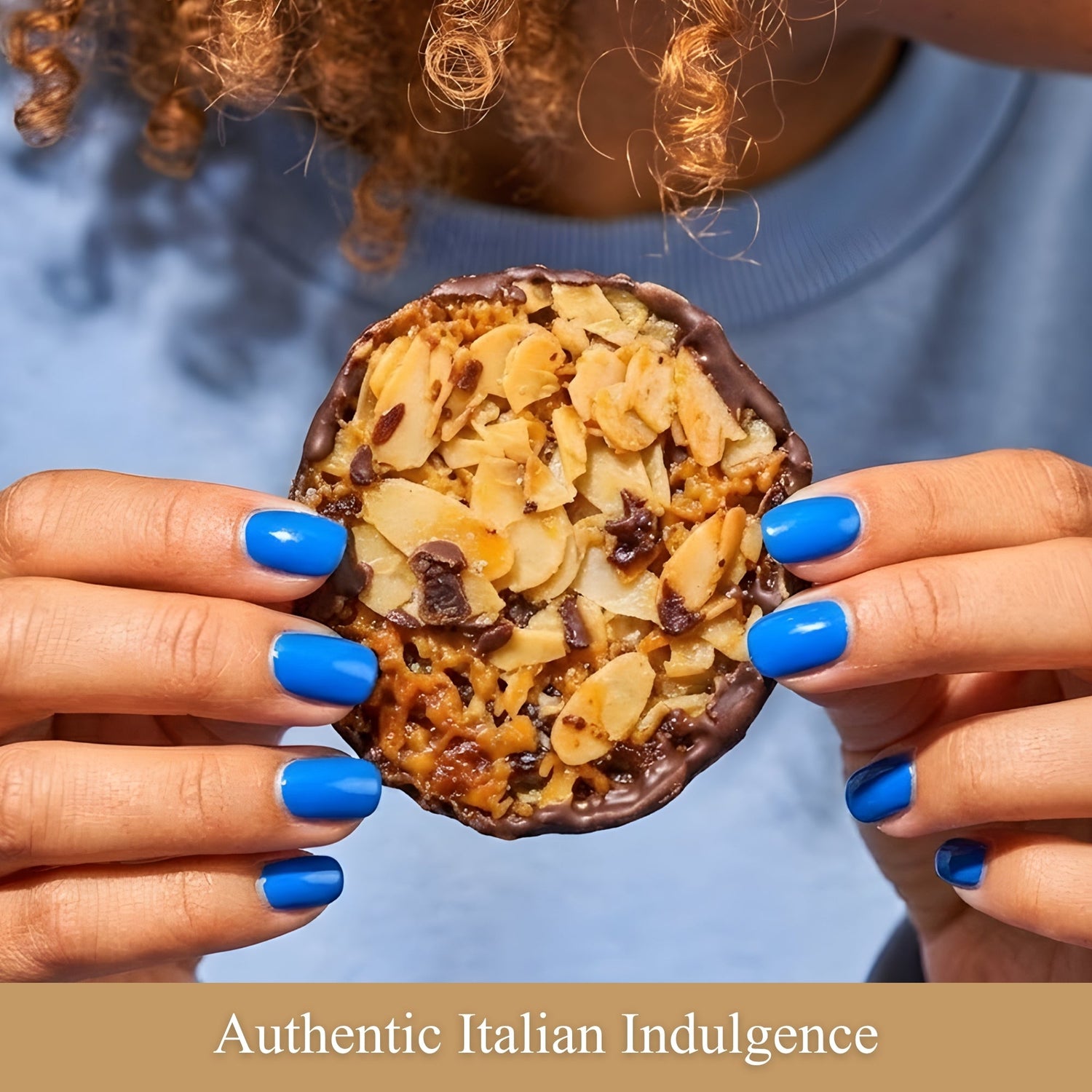 Chocolate-almond florentine cookie held in hands, topped with sliced almonds