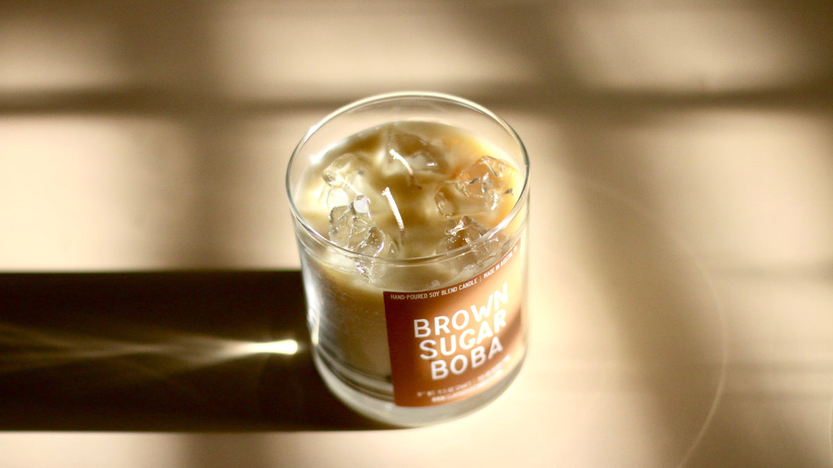 Glass jar candle with amber wax, visible wick, Brown Sugar Boba label