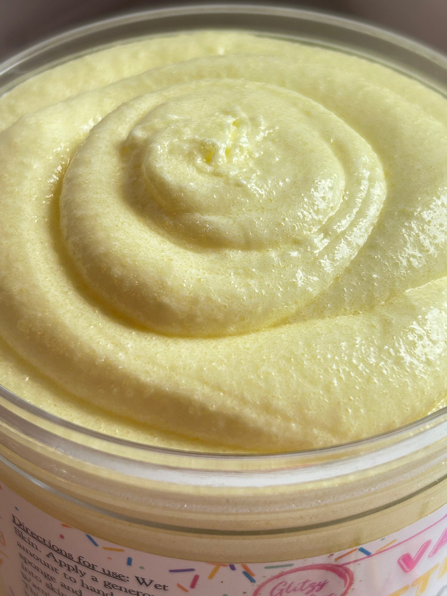 Lid jar with pale yellow sugar scrub swirl, smooth whipped texture