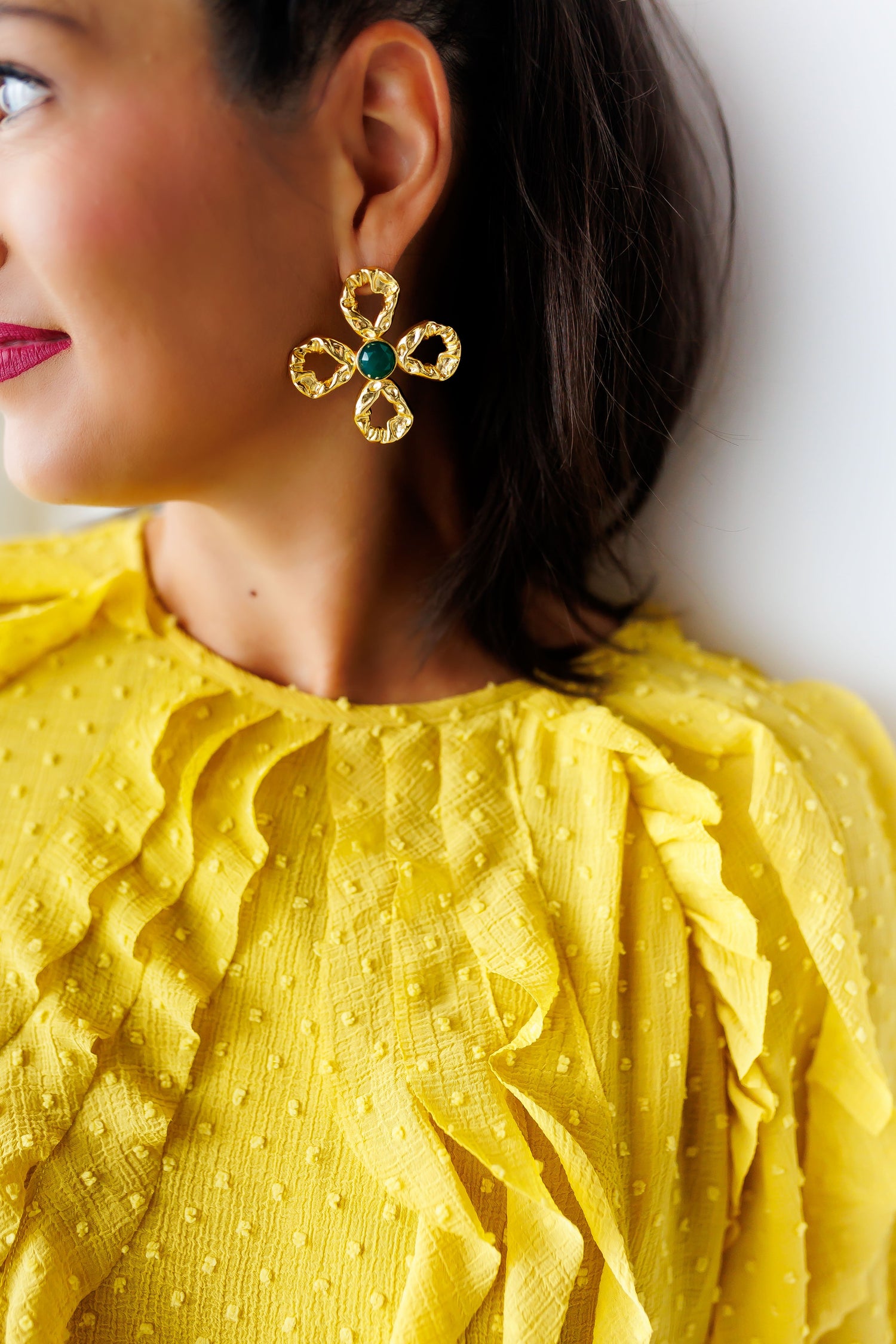 Gold flower drop earrings with green center stone and scalloped dangling petals