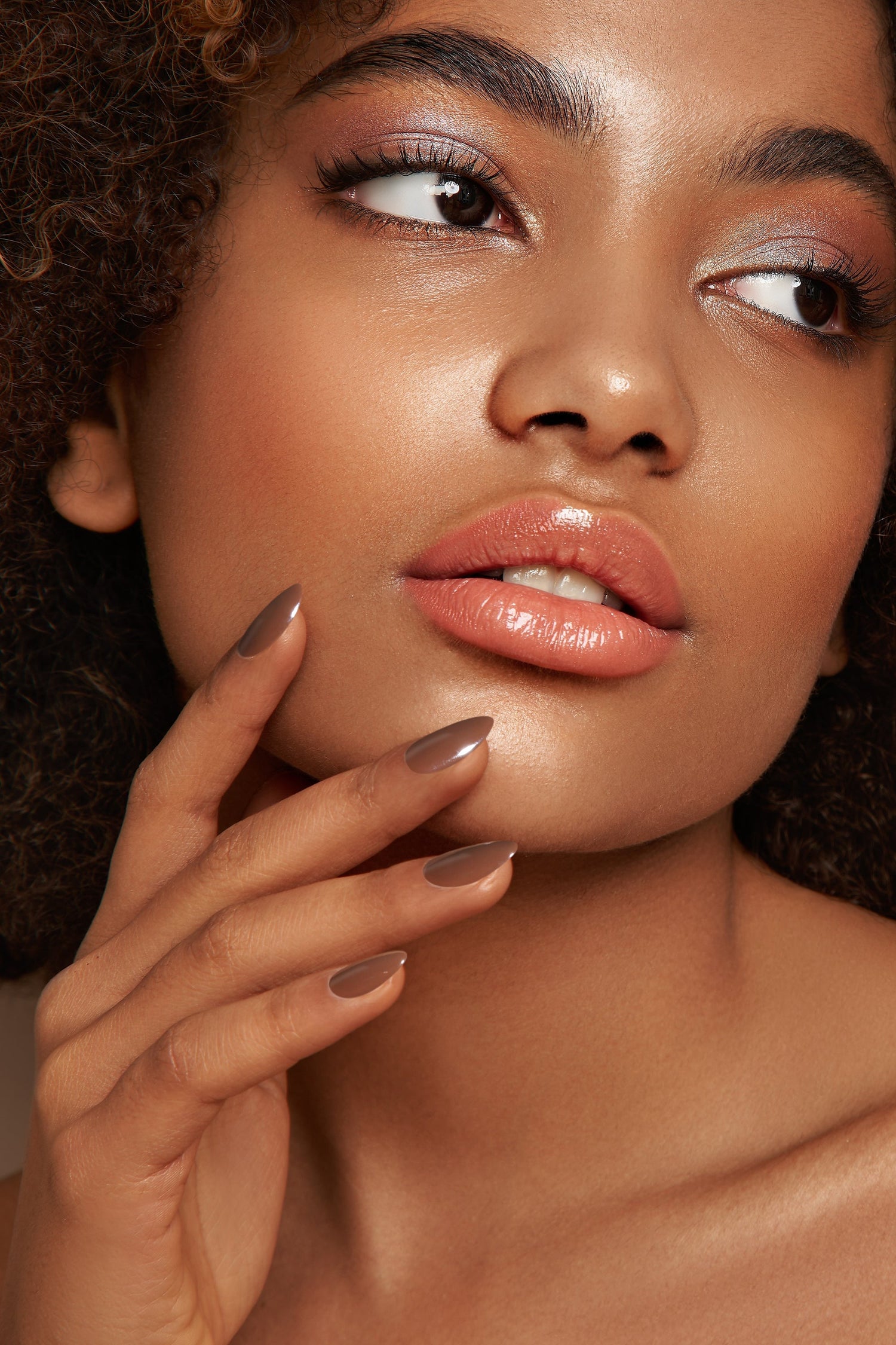Long glossy dark brown press-on nails on model's fingers