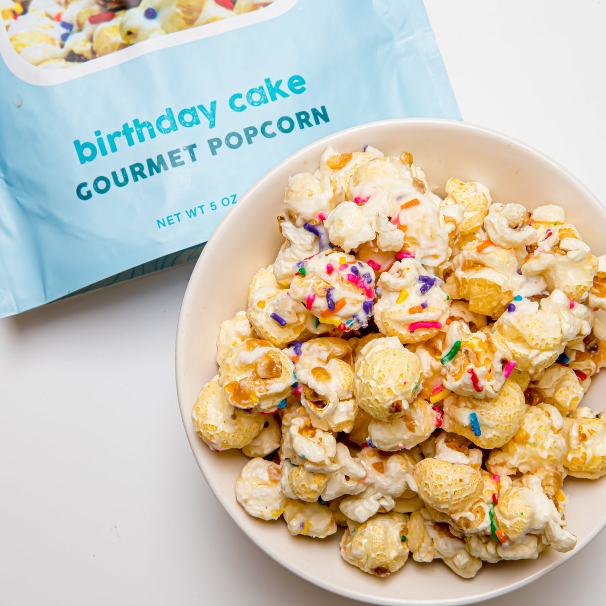 Bowl of birthday cake gourmet popcorn with colorful sprinkles and caramel bits