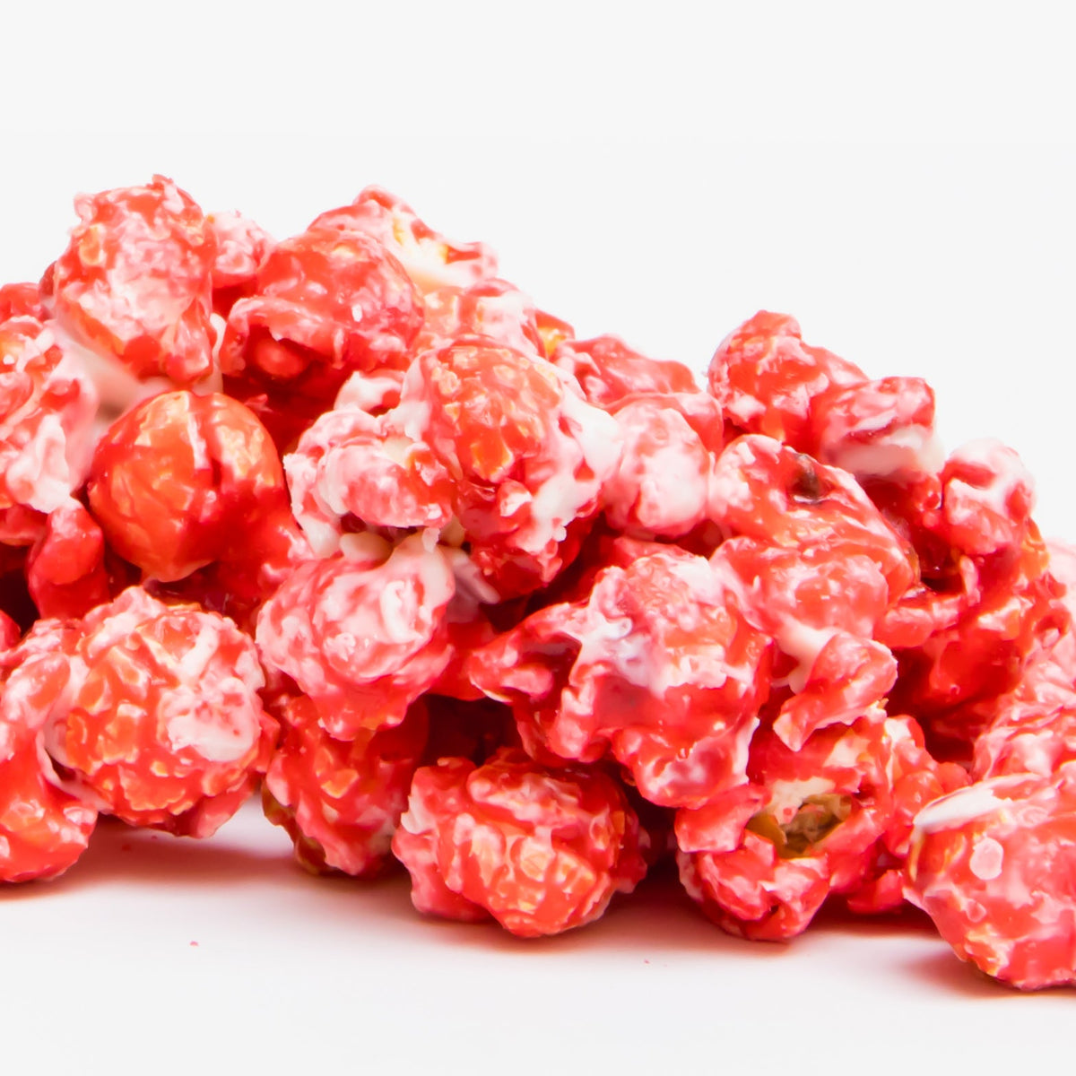 Raspberry white chocolate popcorn, red-and-white coated popped kernels close-up
