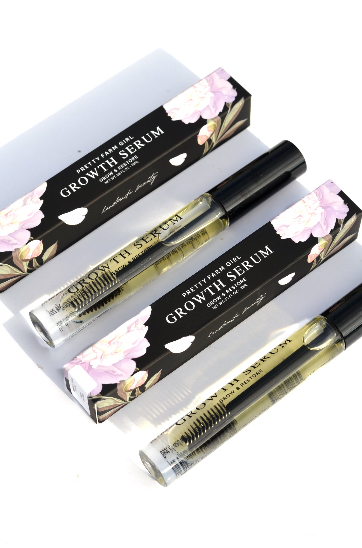 Growth serum set with two boxes and two clear bottles with black caps