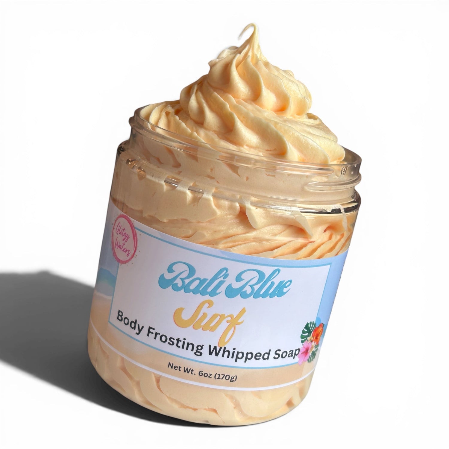 Whipped body frosting soap in clear jar, creamy tan swirled top