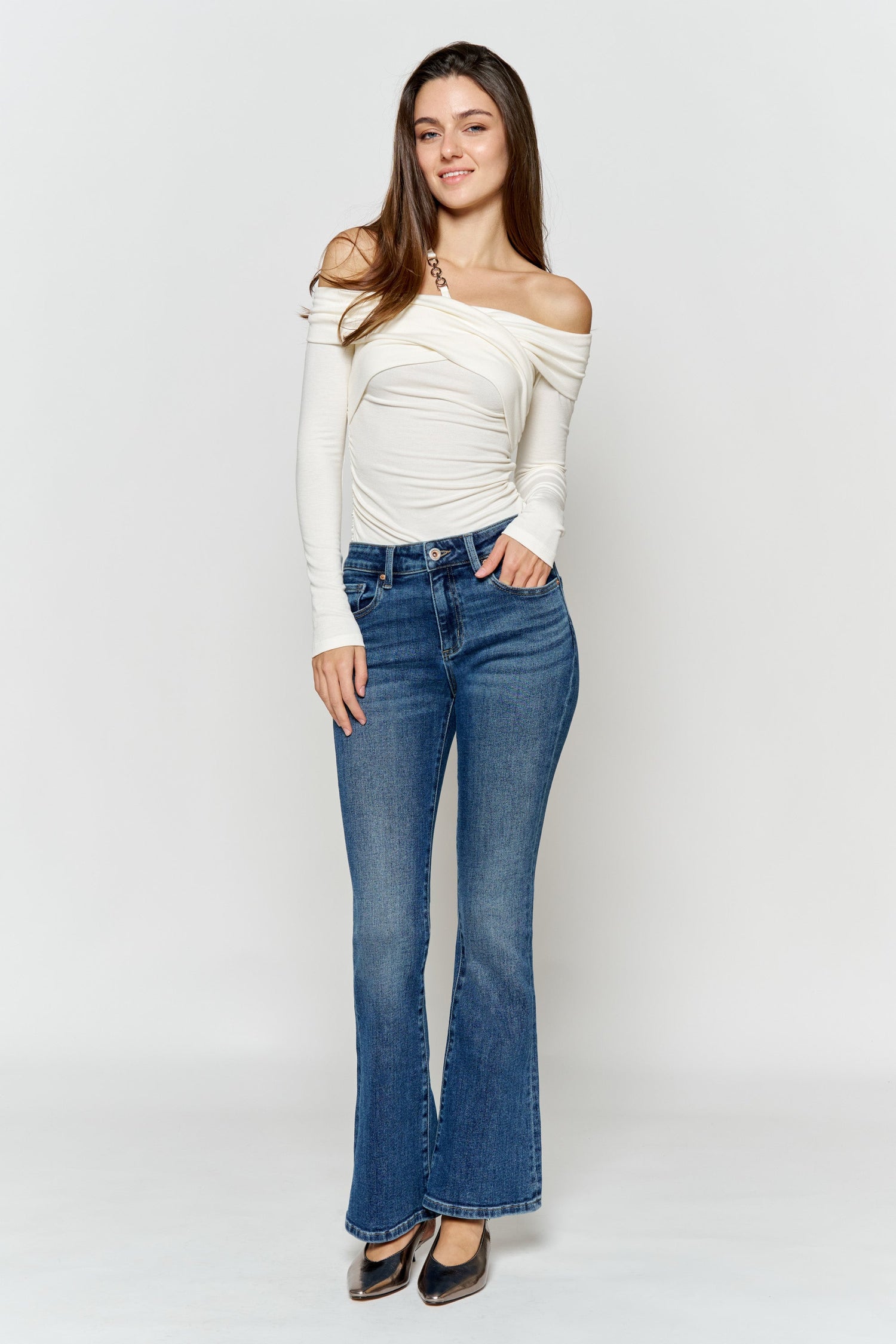 High-rise bootcut jeans in medium-wash blue, flared legs with front button and pockets