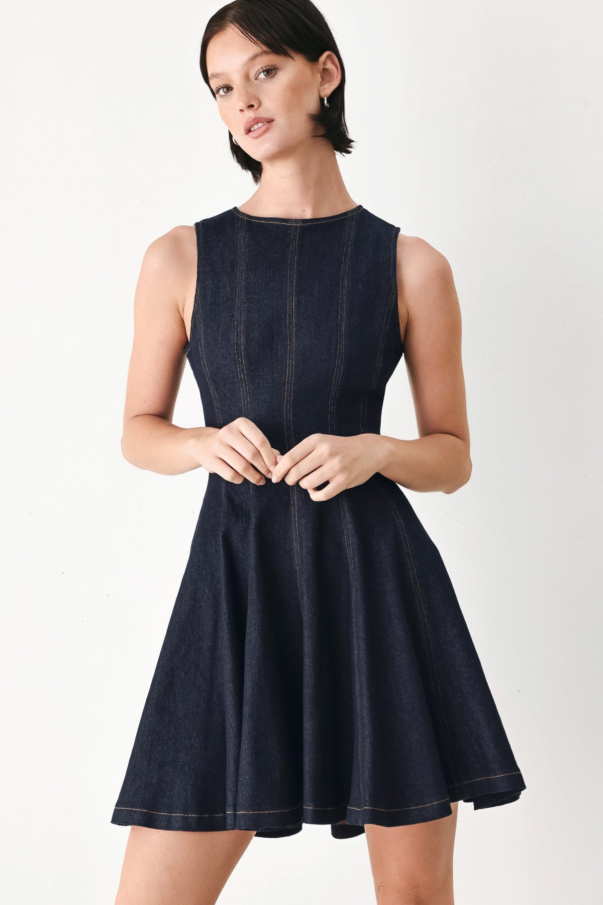 Dark denim sleeveless mini dress with high neck, flared skirt and front seam stitching
