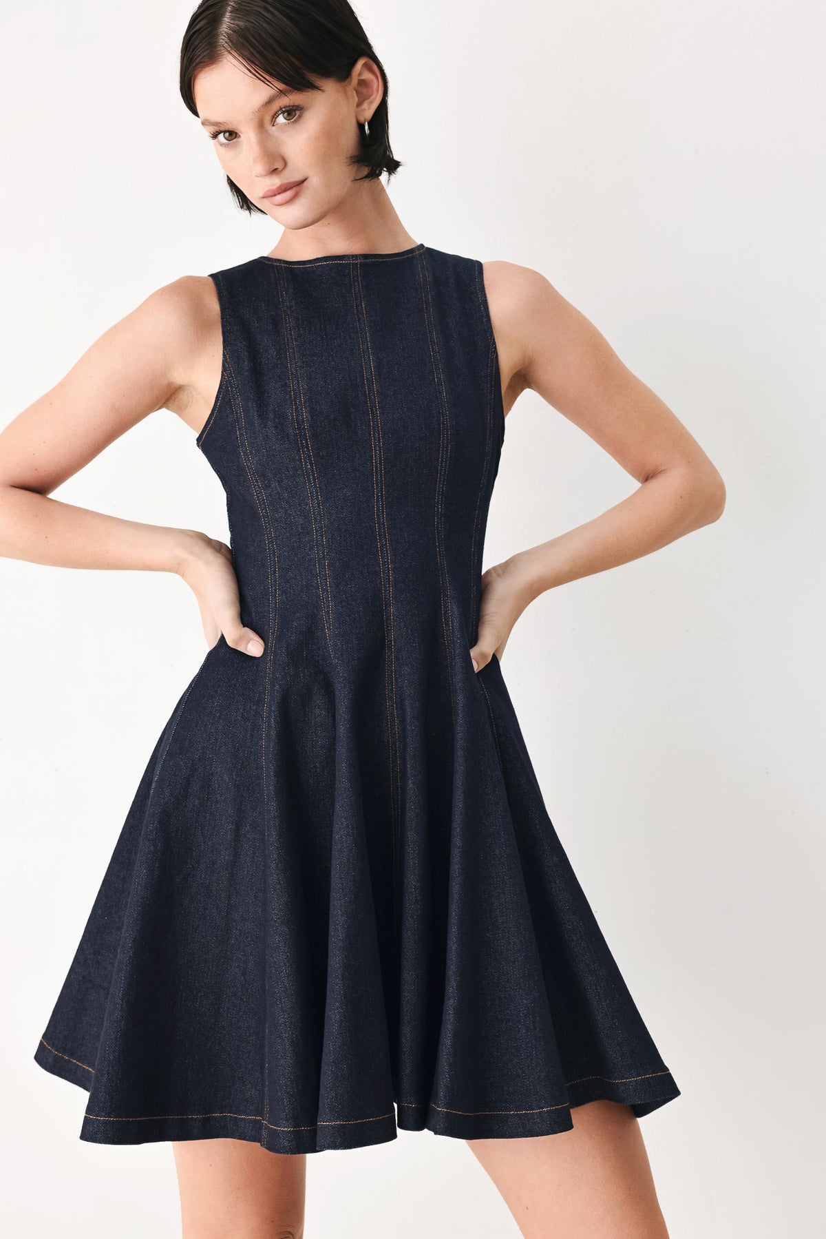 Dark denim sleeveless mini dress with high neck and swing skirt, vertical stitch detailing
