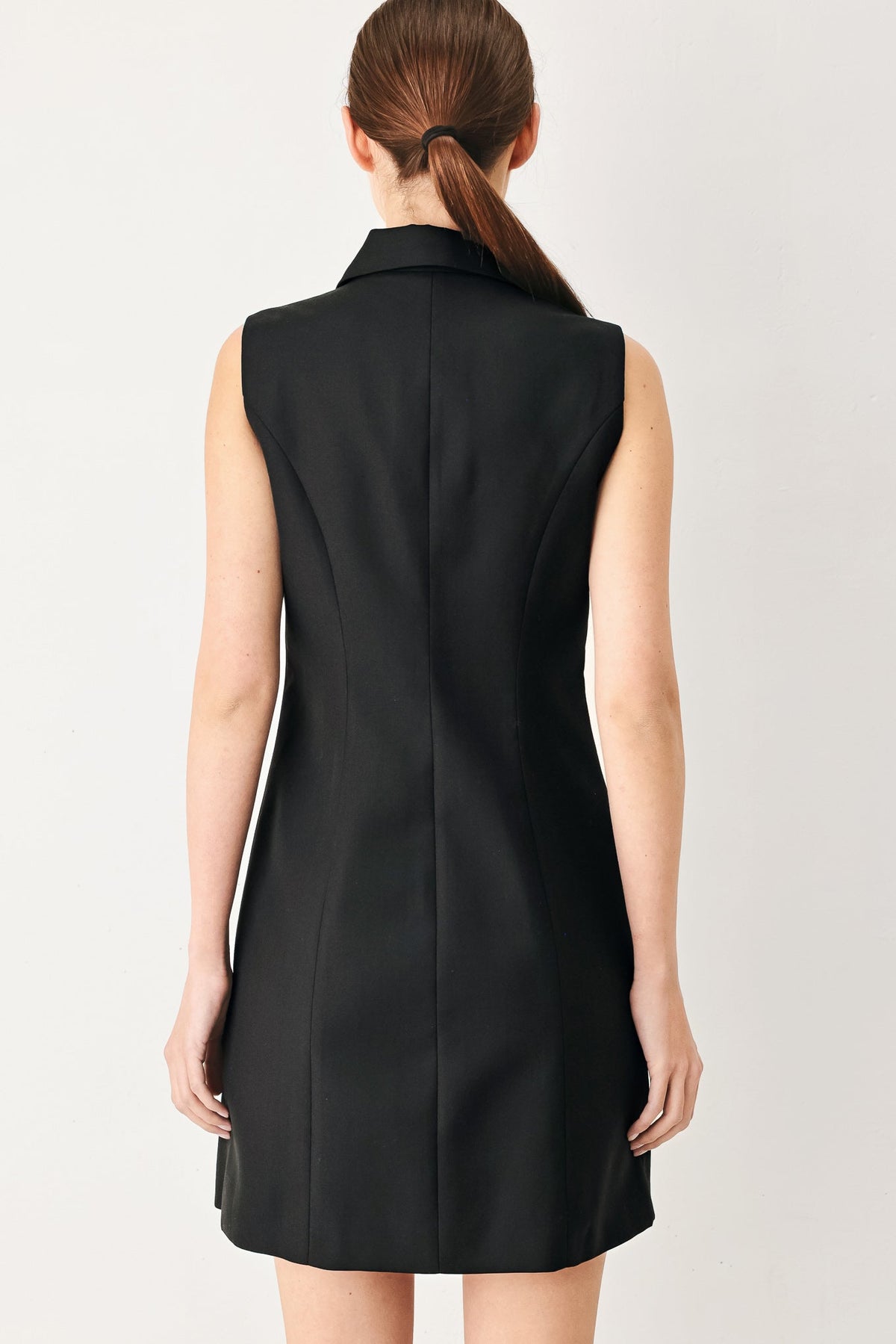 Black sleeveless woven mini dress with center back seam and straight back silhouette