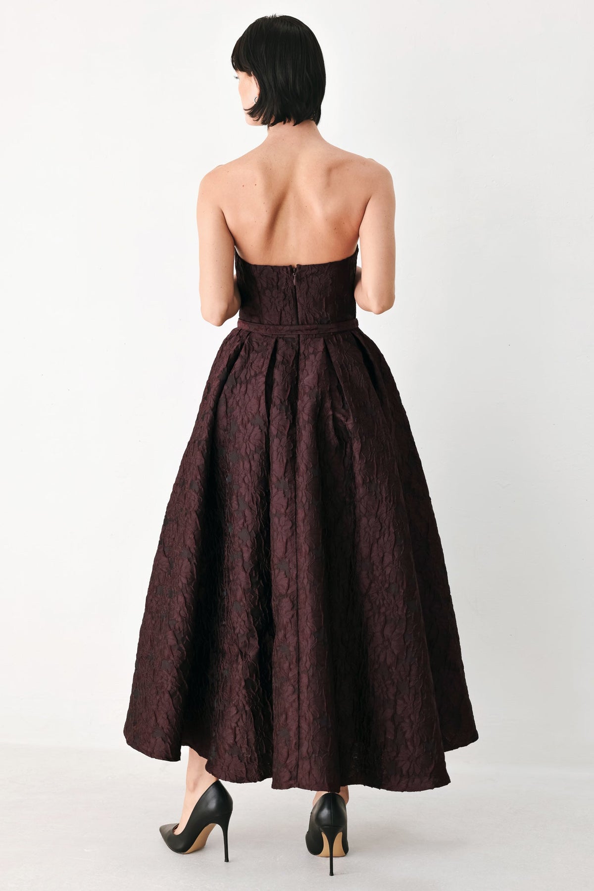 Burgundy strapless woven midi dress back view with fitted waist and flared skirt
