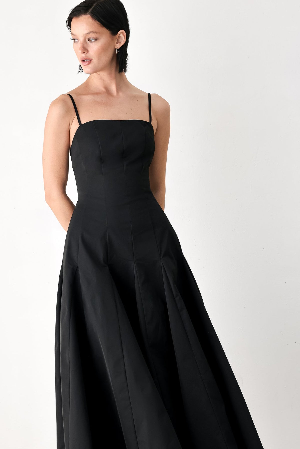 Black midi dress with thin straps, fitted bodice, full flared skirt