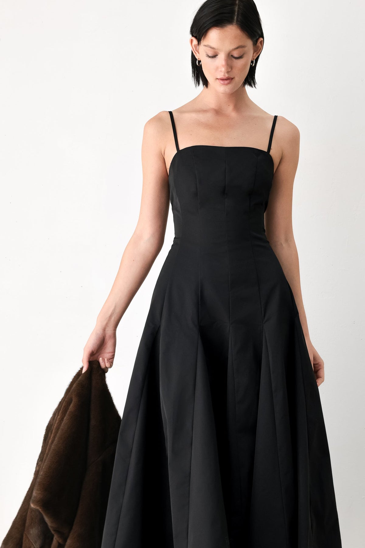 Black midi dress with spaghetti straps and square neckline, pleated full skirt