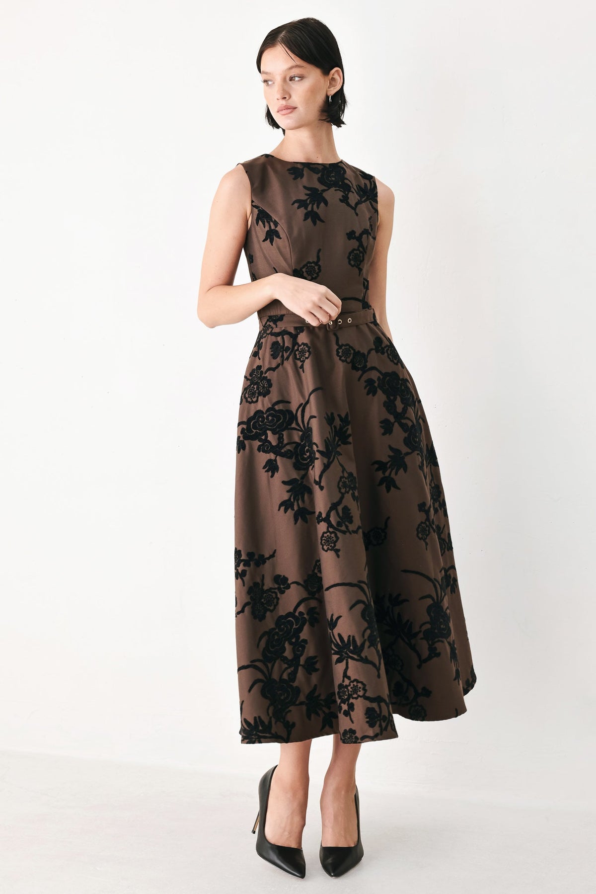 Brown woven midi dress with black floral pattern, sleeveless cut and waist belt