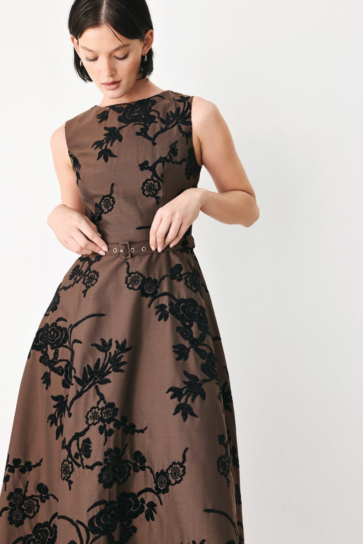 Brown sleeveless midi dress with black floral print and eyelet buckle waist belt detail