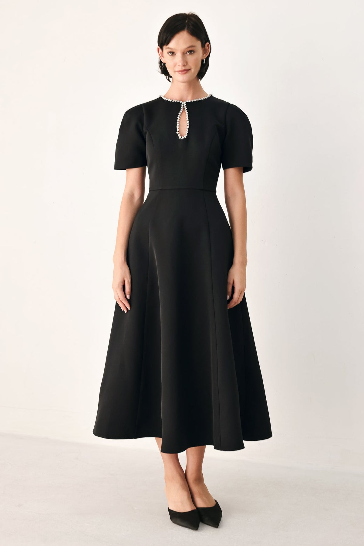 Black midi dress with jeweled teardrop neckline, short puff sleeves, fitted waist, flared skirt.