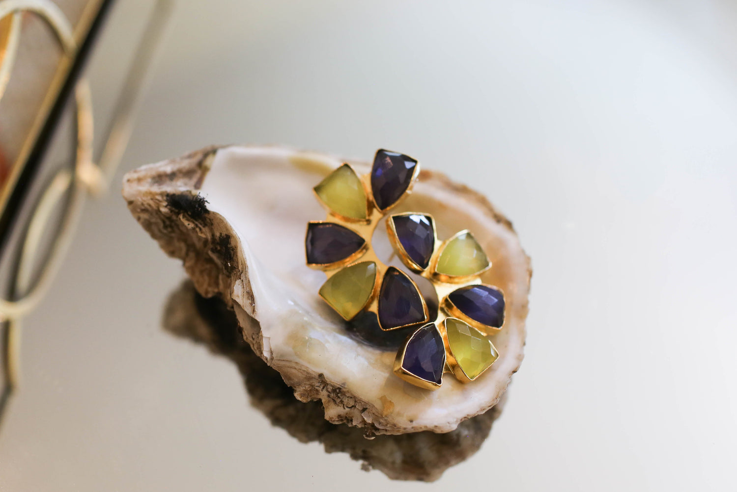 Purple and yellow flower-shaped stud earrings with triangular pieces, close-up
