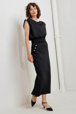 Black knit midi skirt with fitted waist and gold buttons; sleek pencil-length