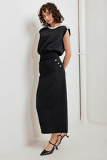 Black knit midi skirt with textured fabric, fitted waist, and gold button accents