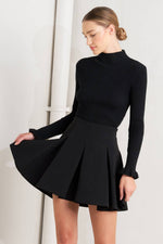 Black woven mini skirt with structured pleats and flared A-line silhouette
