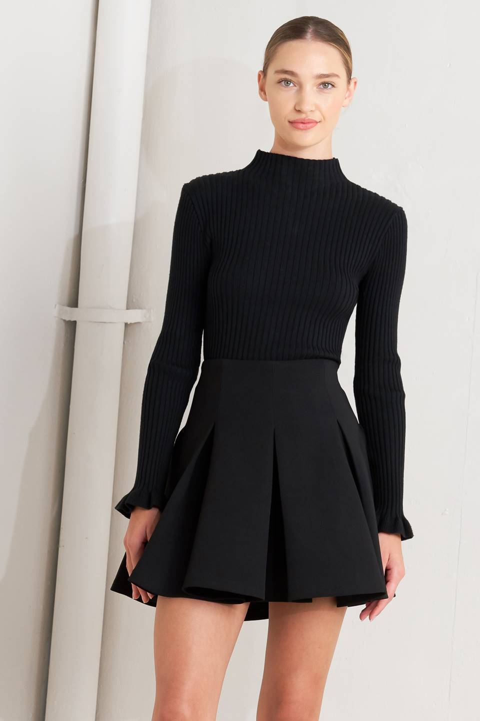 Black woven mini skirt with high-waist pleats and flared skirt front
