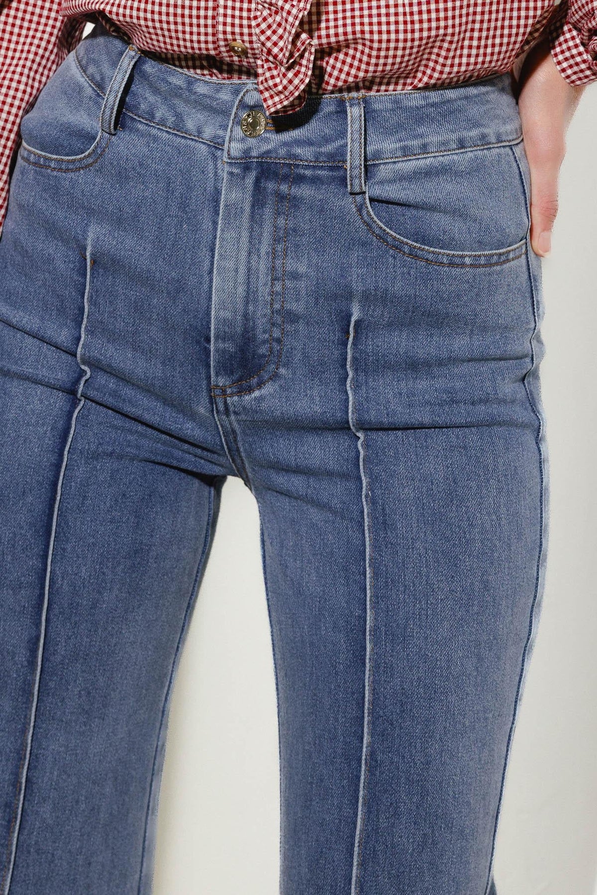 Medium wash stretch denim jeans with front pocket, button waistband, and stitched seams