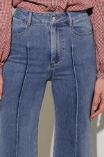 Medium wash stretch denim jeans with front pockets, button fly, and belt loops
