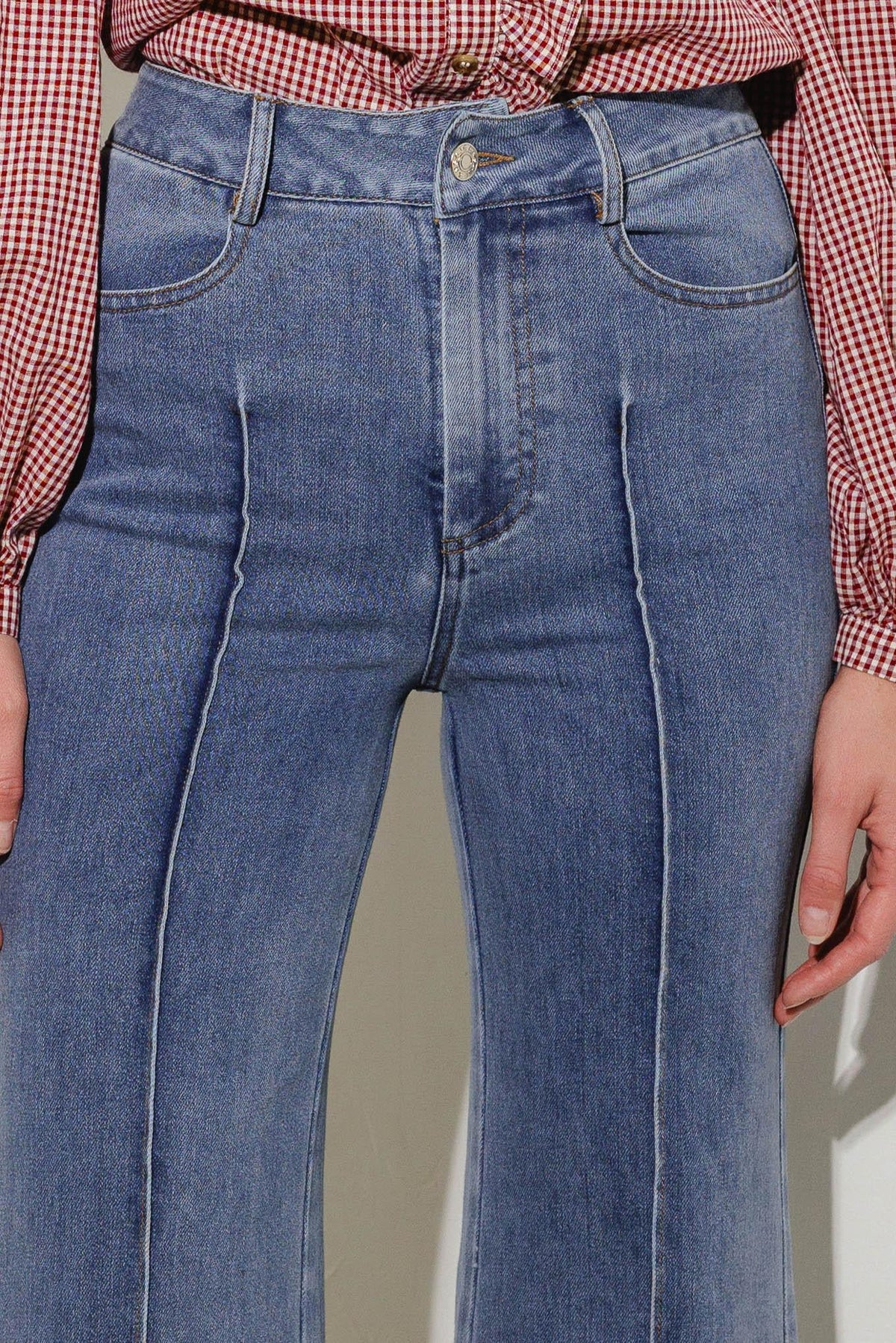 Medium wash stretch denim jeans with front pockets, button fly, and belt loops