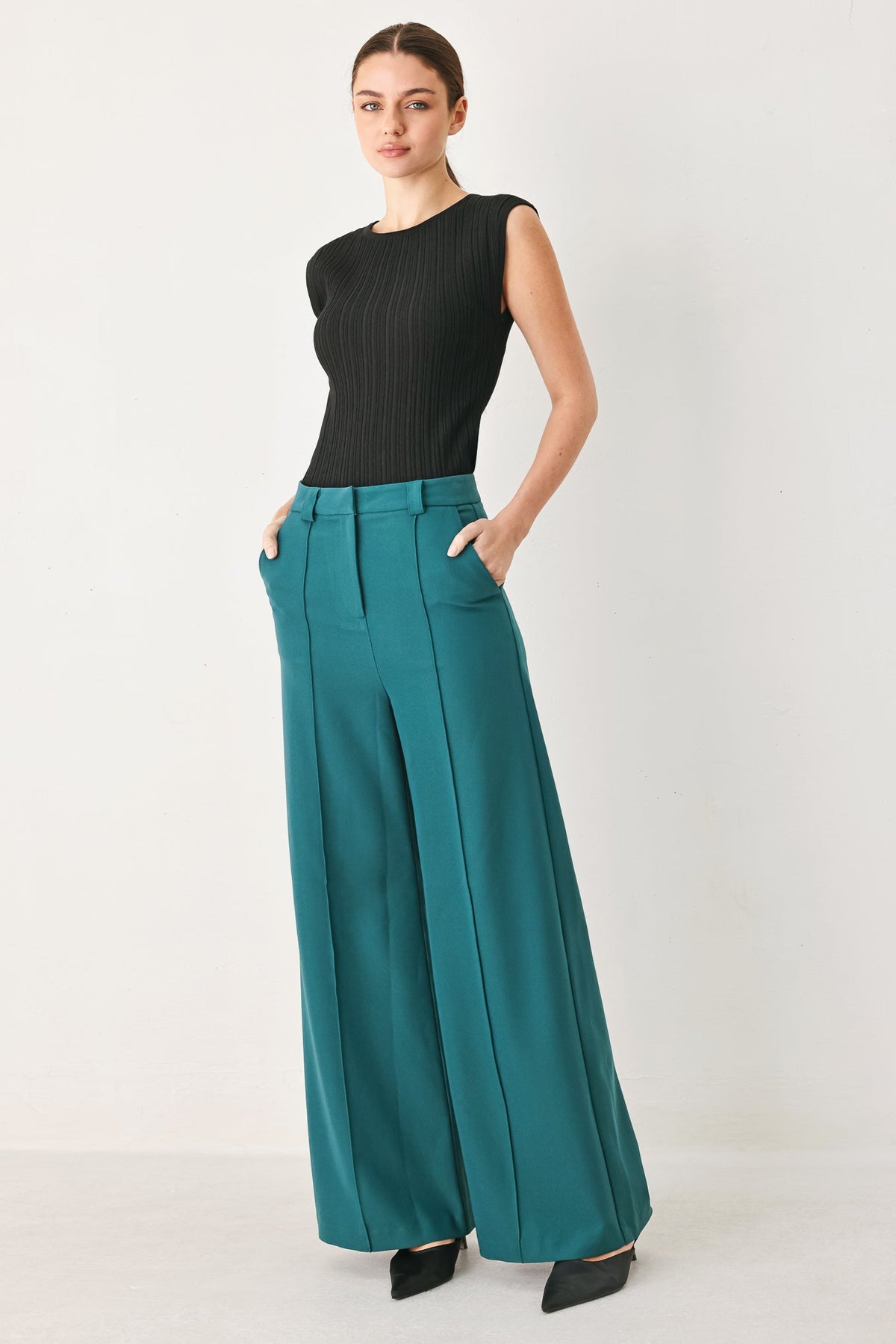 Teal woven wide-leg pants with high waist, front pleats, belt loops, side pockets.