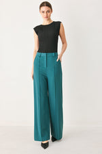 Teal woven high-waist wide-leg trousers with front pleats, belt loops, side pockets.