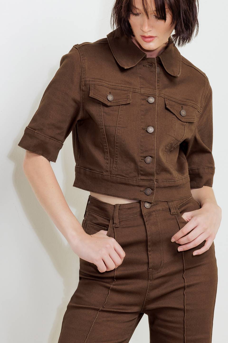 Close-up of women’s brown twill pants: button closure, front pockets, and belt loops.