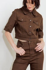 Close-up of women’s brown twill pants: button closure, front pockets, and belt loops.