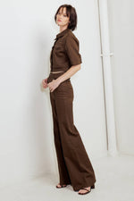 Brown twill pants with wide legs, side pockets, and button front