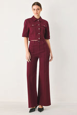 Women’s burgundy twill pants with high-rise waist, wide legs, and button-front closure.