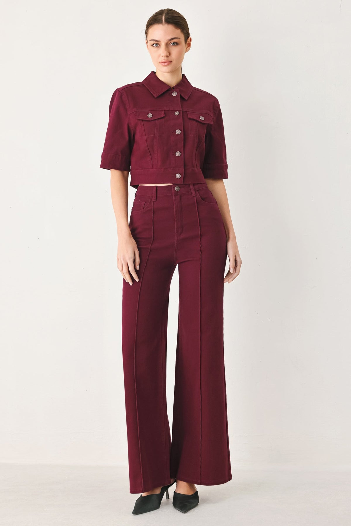 Women’s burgundy twill pants with high-rise waist, wide legs, and button-front closure.