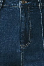 Indigo denim pants close-up of front pocket stitching and curved seam details