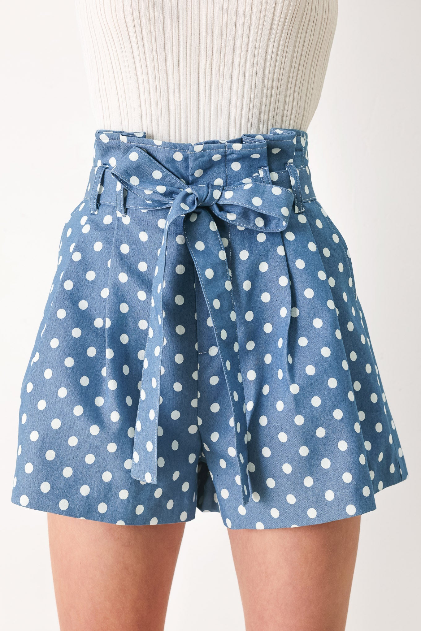 Light denim woven shorts with white polka dots and knotted waist tie