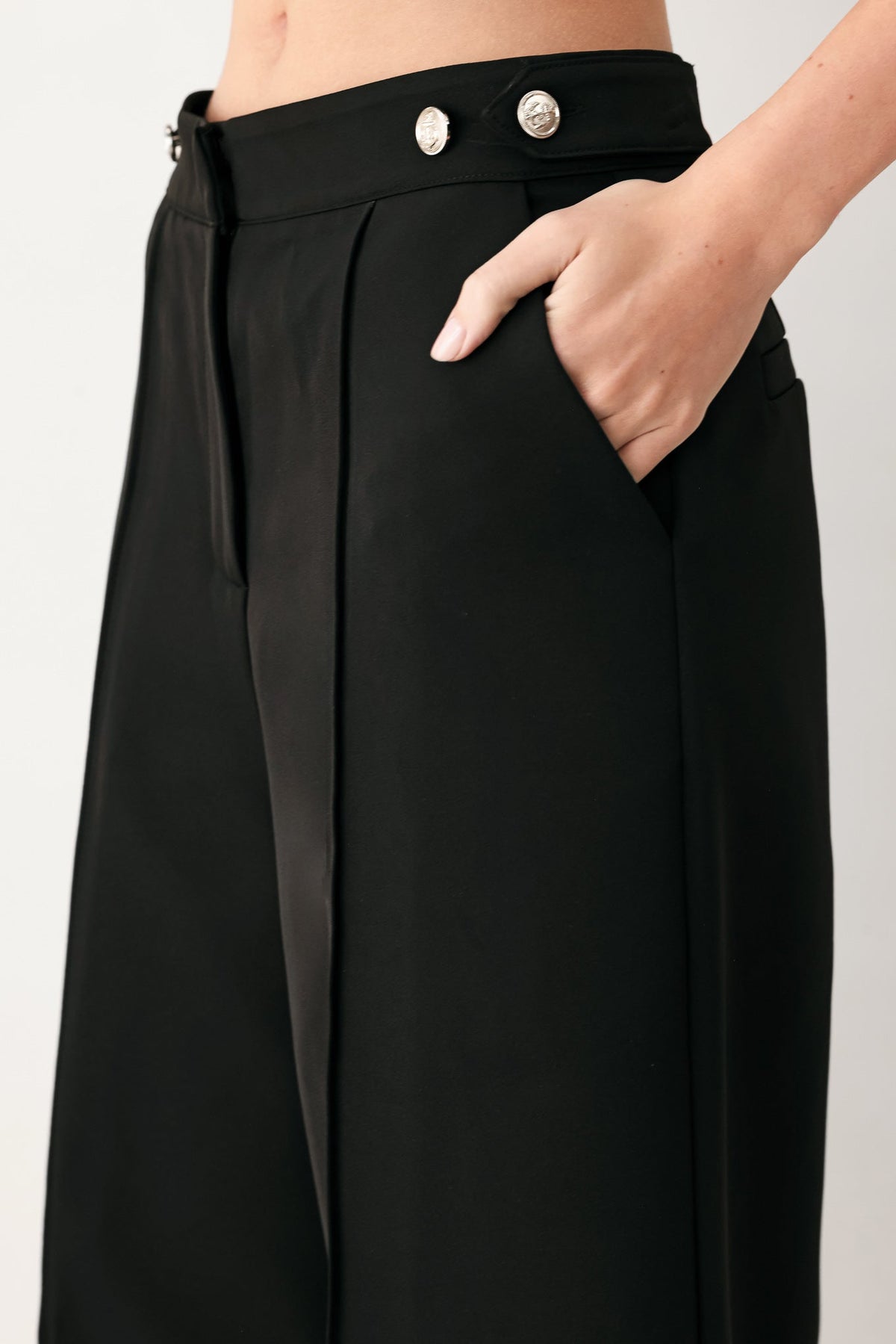 Black high-waisted palazzo pants with two silver buttons on waistband