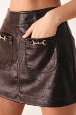 Brown embossed faux leather skort close-up of flap pocket and metal buckle