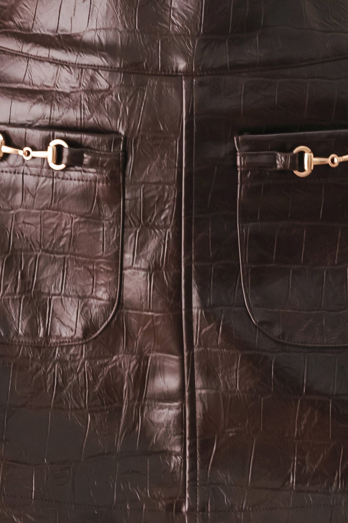 Brown embossed faux leather skort close-up of two buckled flap pockets
