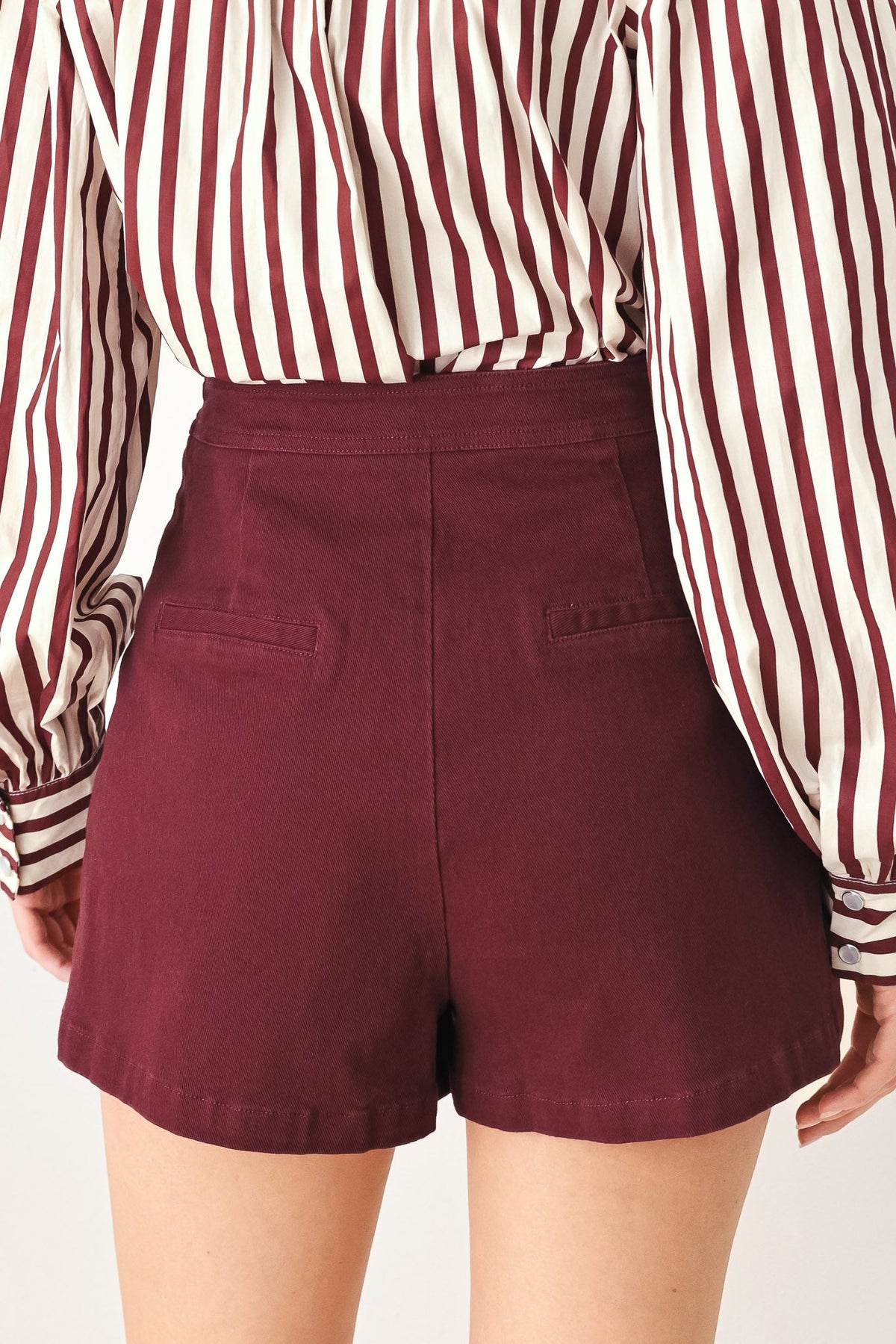 Burgundy woven skort with tailored shorts silhouette and side panel seams